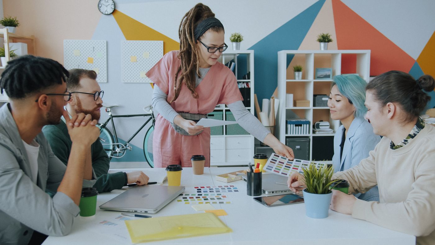 Designers reviewing colour swatches together in a bright studio.