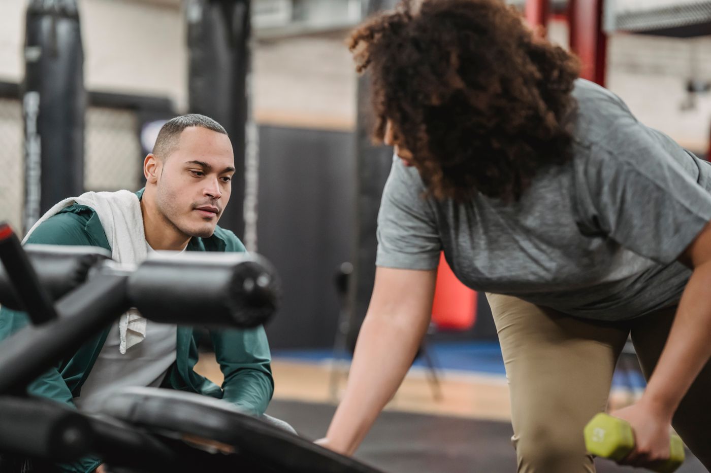 A coach watching a client work through a set in the gym.