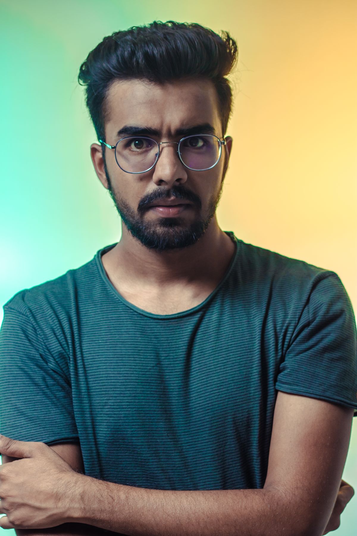 A studio portrait lit with coloured gels against a graduated background.